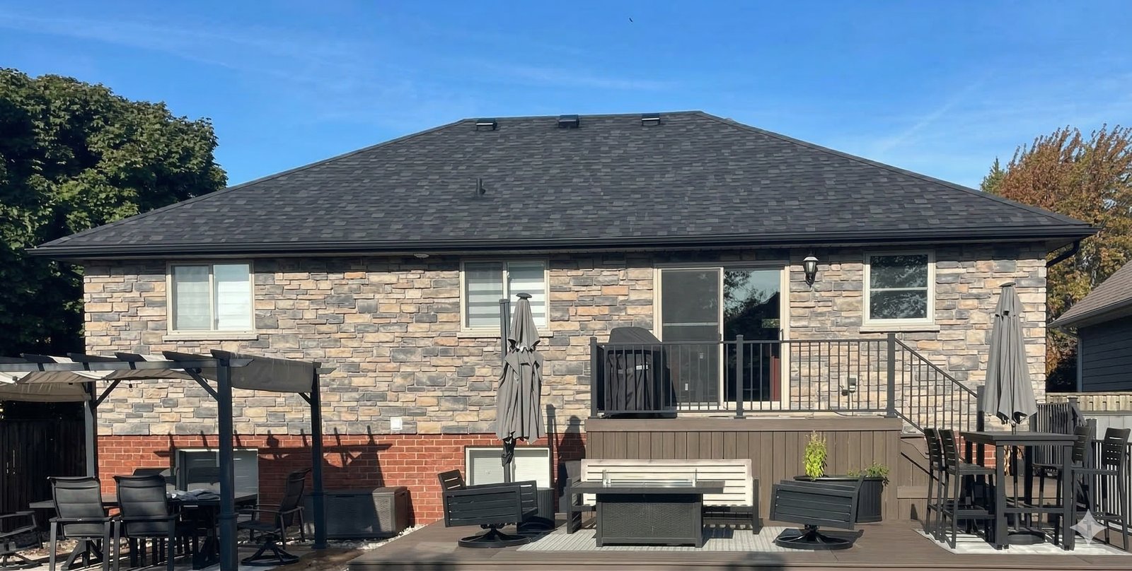 Stone house with dark restored shingles after GreenSoy rejuvenation
